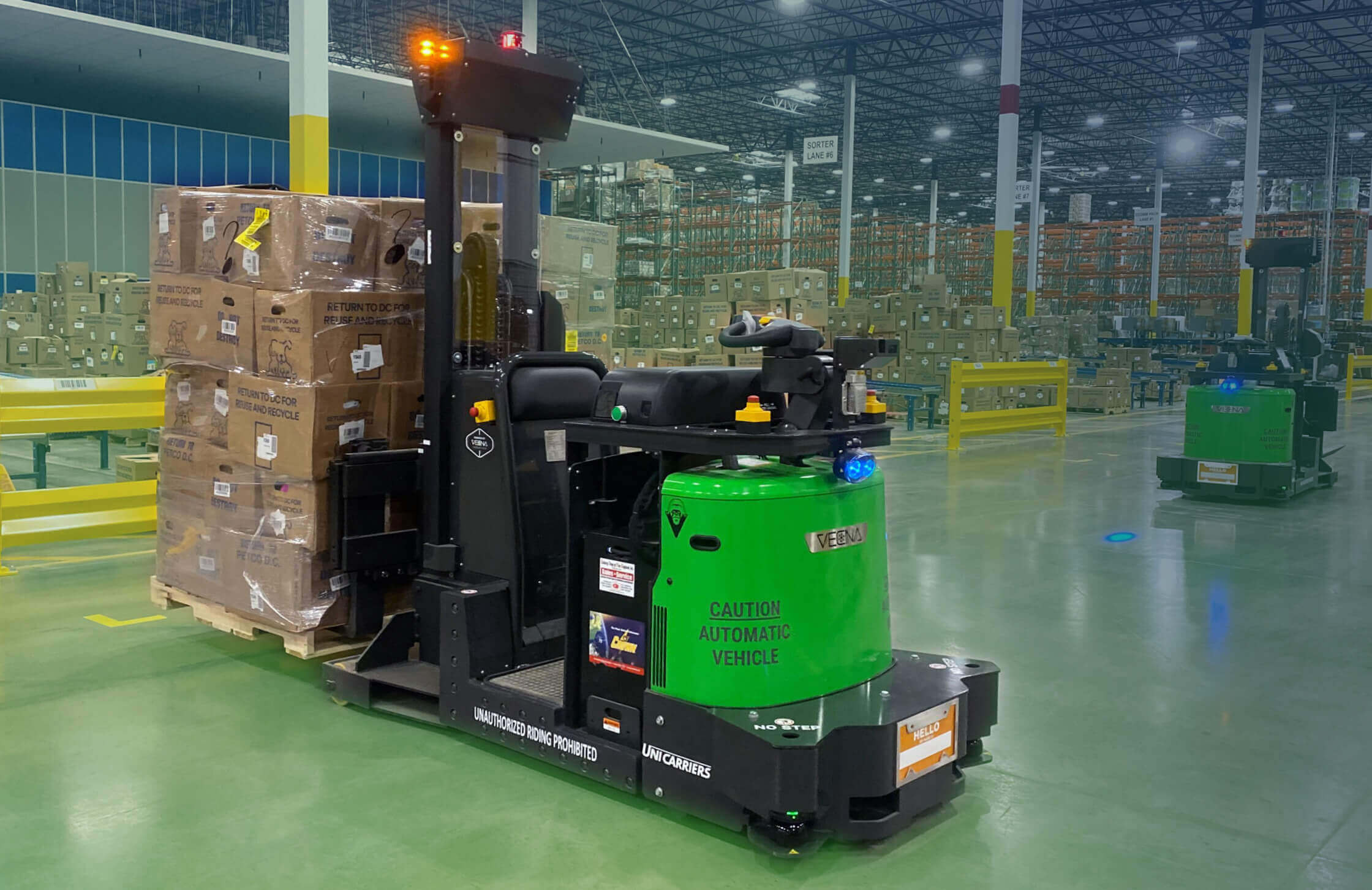 An automated forklift moving a pallet of boxes